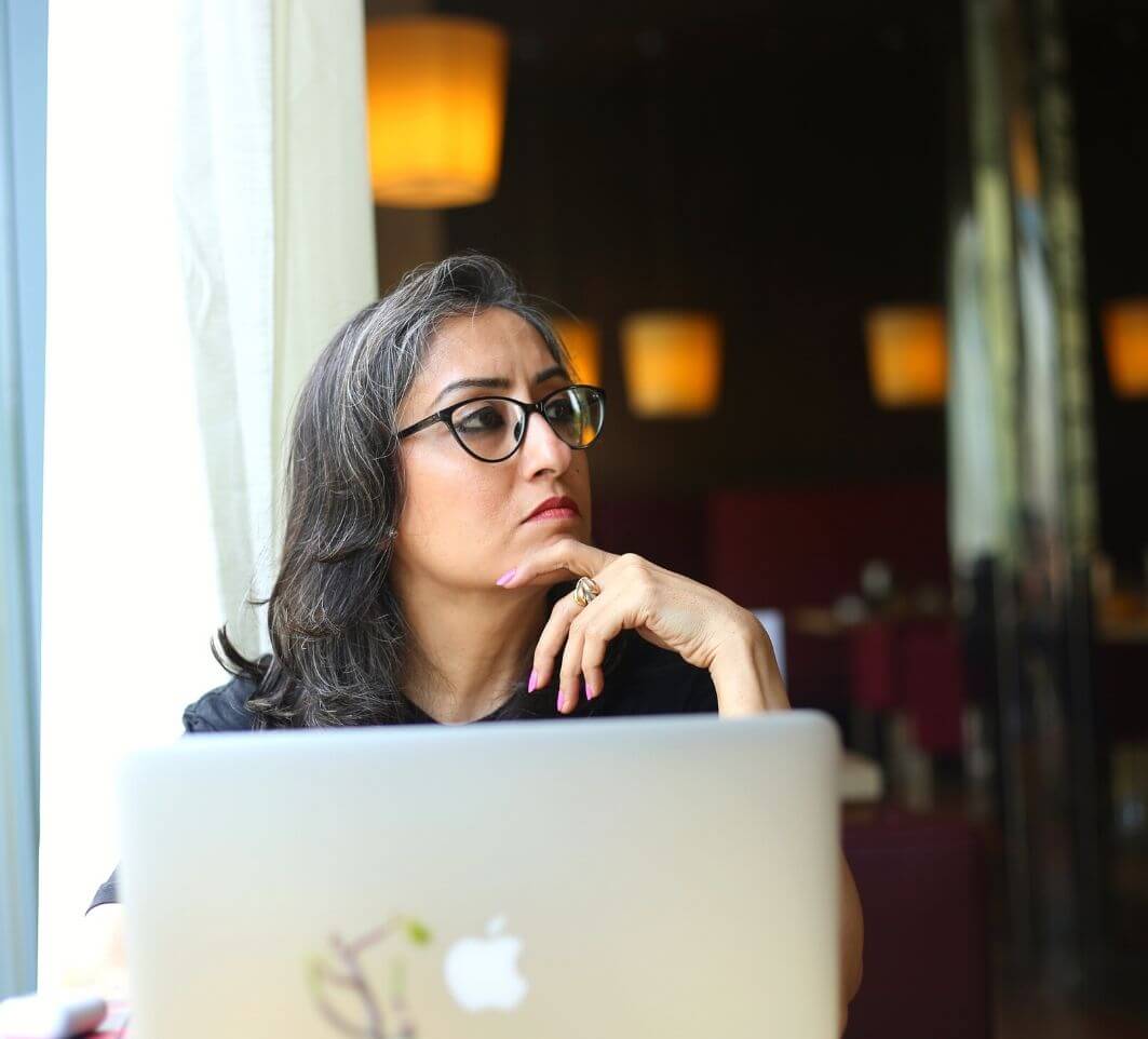 A Woman With Specs & laptop thinking